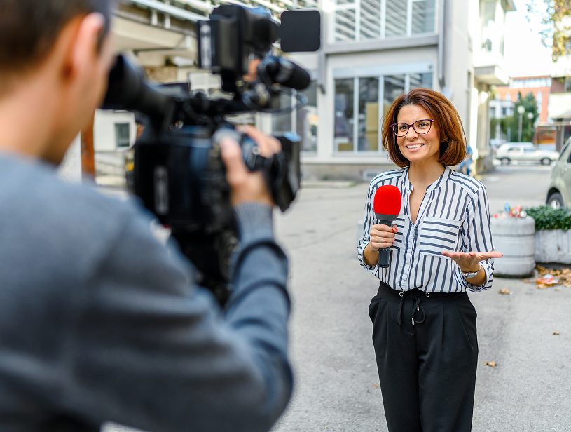 Journalist reporting news on street