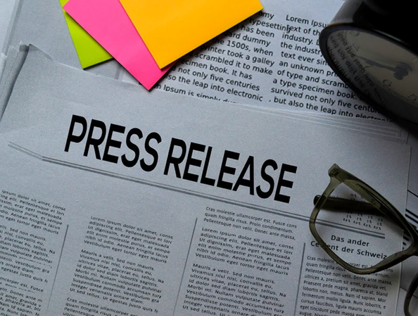 Press release headline on newspaper with glasses.