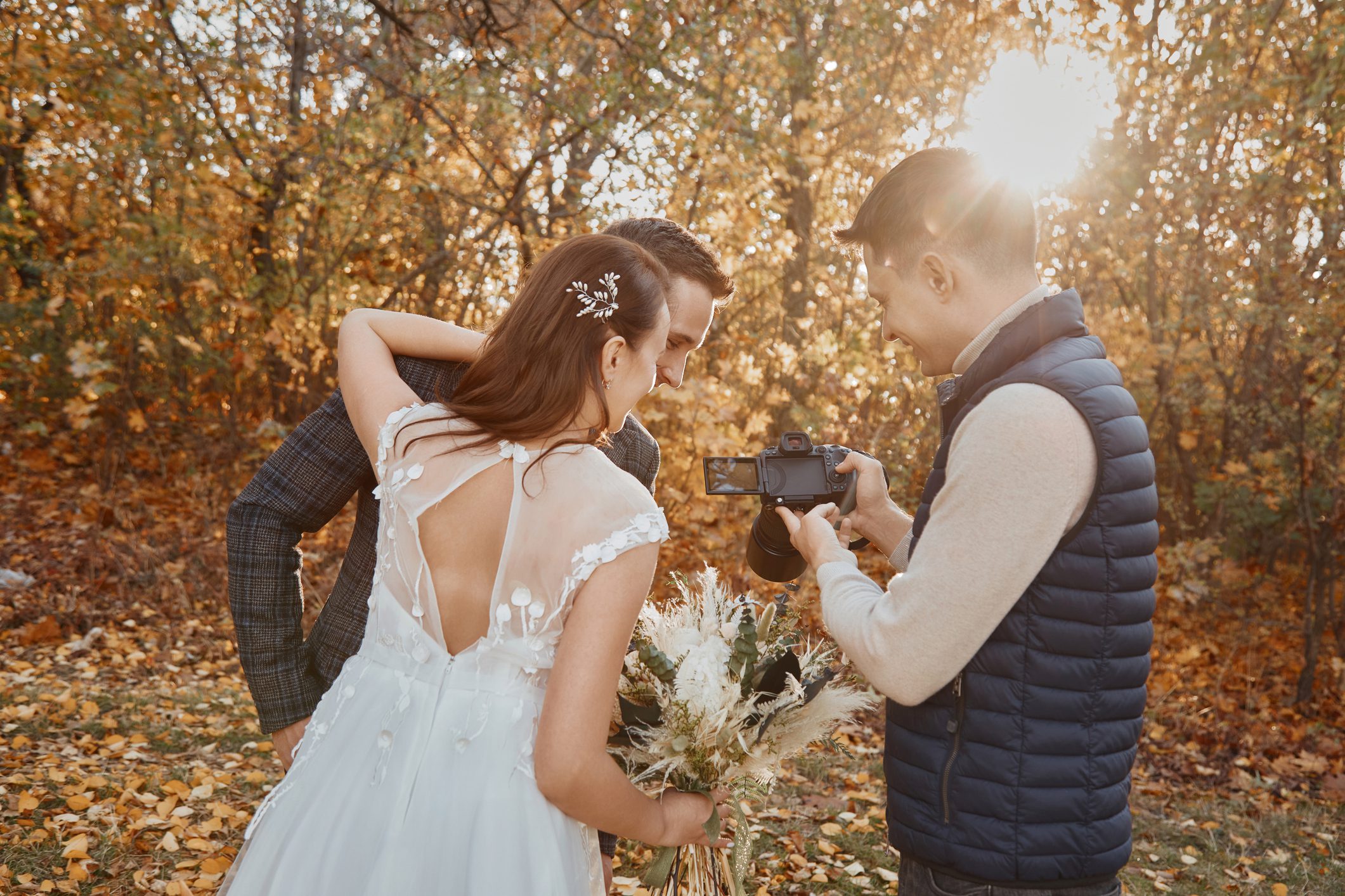 Wedding couple reviewing photos with photographer.