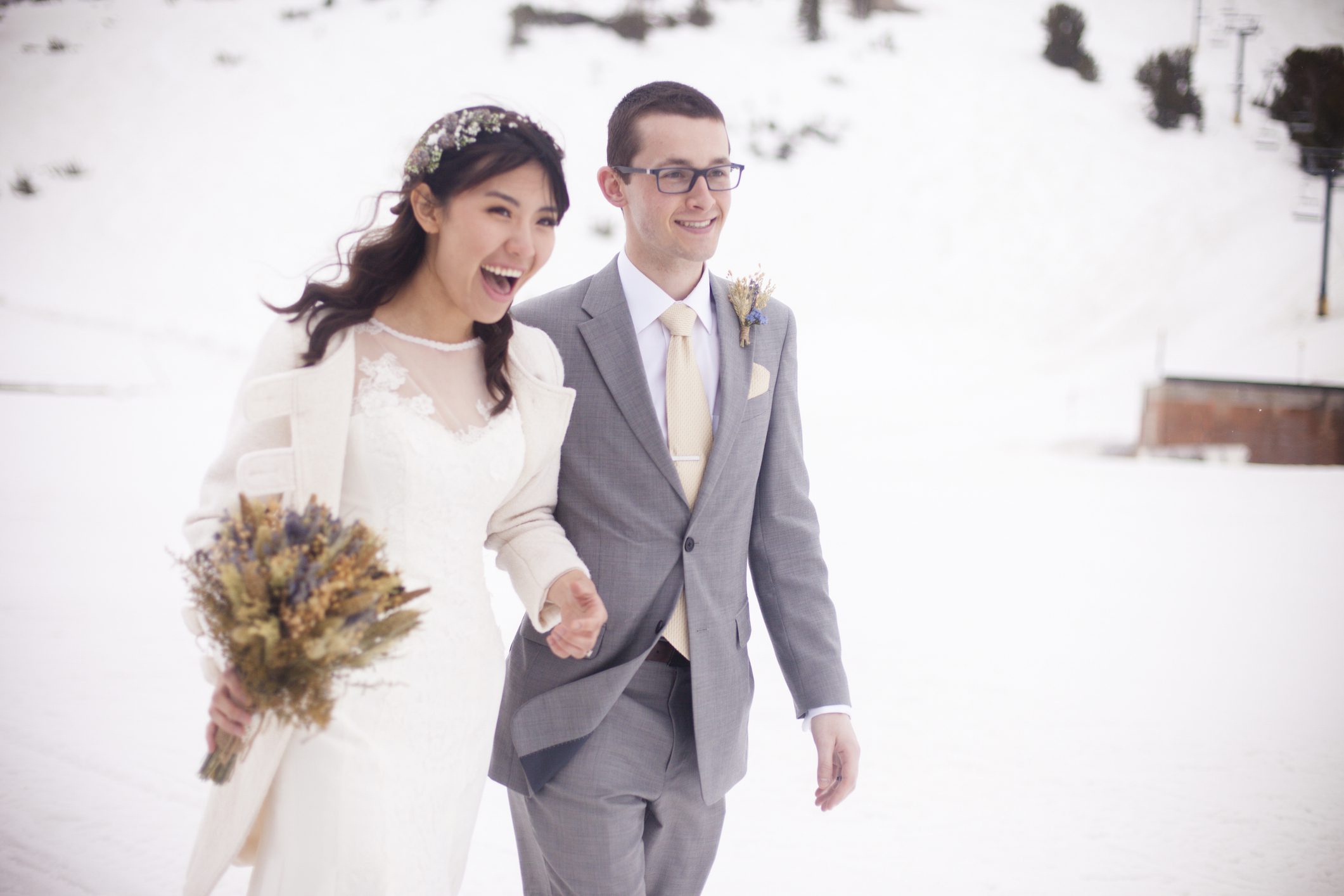 Bride and groom smiling in snowy landscape.